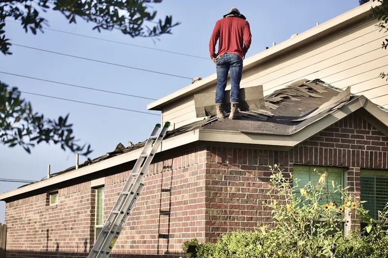 Professional roofer working on a residential roof in Milwood